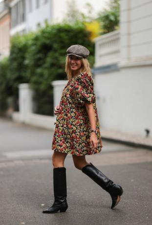 Een vrouw laat zien hoe je een dutjesjurk met westernlaarzen kunt stylen