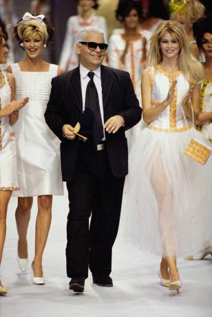 As supermodelos Linda Evangelista (à esquerda) e Claudia Schiffer (à direita) se vestem do estilista alemão Karl Lagerfeld para a casa de moda francesa Chanel no desfile de moda primavera-verão de 1996.