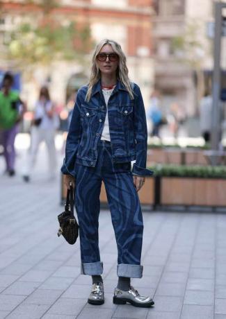 Показывая, как носить лоферы с джинсами, Полли Сэйер носит серебристые лоферы Prada с двухцветными джинсами с рисунком.