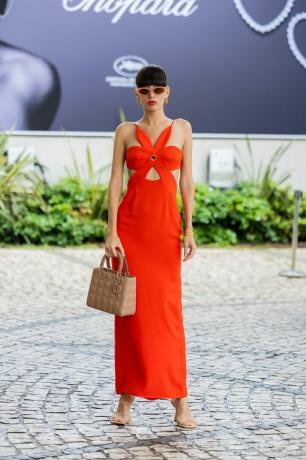 Una mujer lleva un vestido rojo con recortes sutiles, una idea casual de vestido de novia