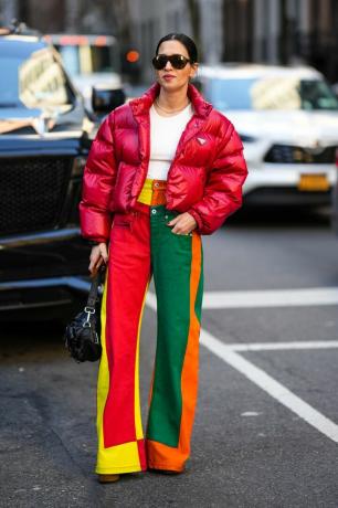 Una donna indossa jeans colorati e jeans patchwork, un tipo di pantaloni che fanno parte della tendenza dei pantaloni divertenti