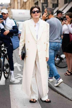 Žena nosí bílý dlouhý kabát
