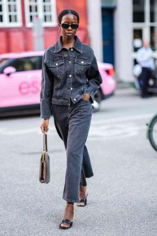 ženska, ki nosi črno jeans jakno in črne kavbojke