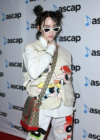 Billie Eilish in einer Power Puff Girls-Jacke und -Hose mit Space Buns und einer Gucci-Satteltasche