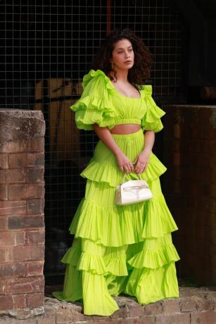 Una mujer luce un conjunto de falda maxi, una idea de outfit para una boda informal.