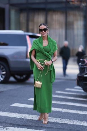Žena nosí zelené šaty a svetr