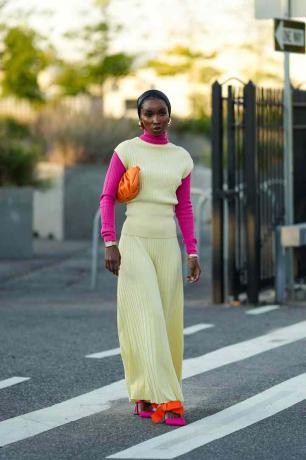 Mujer viste top y falda de color amarillo lima, además de accesorios rosas y naranjas.