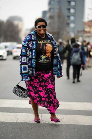 En kvinna bär en grafisk t-shirt och blommig midikjol