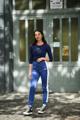 La donna indossa pantaloni da jogging, Converse e top blu scuro