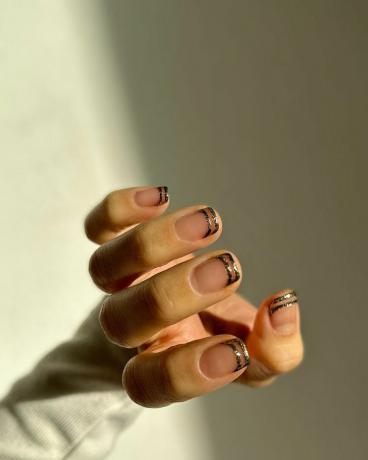 Vrouw draagt ​​een van de beste herfstnagels van 2023, metallic accenten