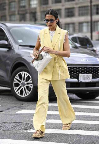Vrouw draagt ​​een casual geel vest en bijpassende broek met Celine-tas