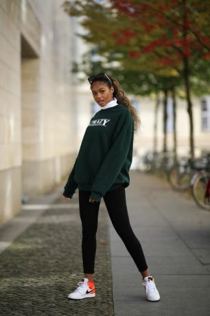 Mauree Ugodi draagt ​​een legging en een trui met ronde hals, een shirt dat je met een legging kunt dragen.