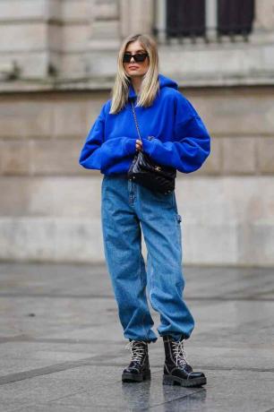 La femme porte un sweat-shirt bleu et un pantalon large bleu