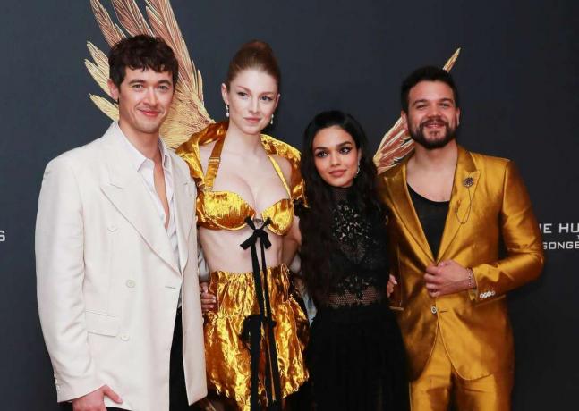 Tom Blyth, Hunter Schafer, Rachel Zegler a Josh Andres Rivera se objímají na červeném koberci na světové premiéře filmu 'The Hunger Games: The Ballad of Songbirds & Snakes'