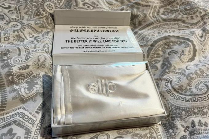 Μαξιλαροθήκη Slip Pure Silk που εμφανίζεται στο κουτί της σε ένα πάπλωμα