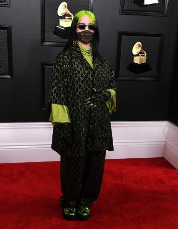 Billie Eilish con un traje Gucci negro y verde brillante de gran tamaño y una máscara facial