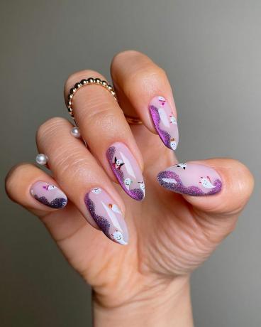 Vrouw draagt ​​een van de beste herfstnagels van 2023, glitter swirls