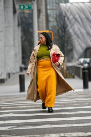 une femme portant une jupe jaune et un trench-coat