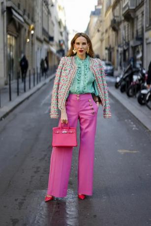 Eine Frau trägt eine Bluse und eine Hose, eine lässige Outfit-Idee für Hochzeitsgäste.