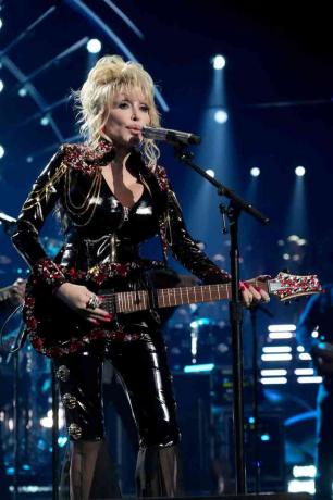 Dolly Parton vystupuje na pódiu během 37. výročního ceremoniálu uvedení do Rock & Roll Hall of Fame v koženém obleku pro kočky
