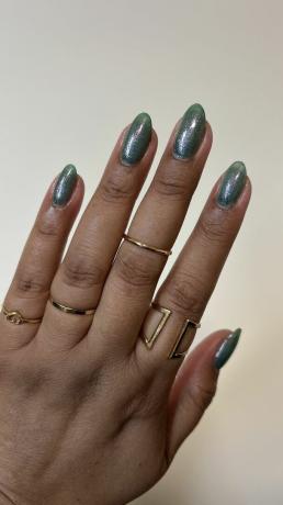 Une femme portant un design d'ongles chromé sauge