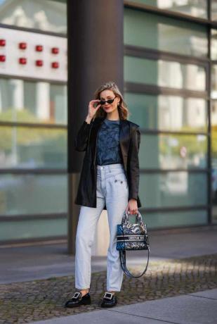 Показывая, как носить лоферы с джинсами, Мэнди Борк сочетает лоферы с пряжками с легкими джинсами.