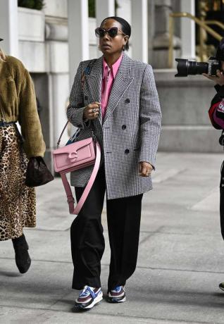 Женщина носит серо-розовый наряд с кроссовками