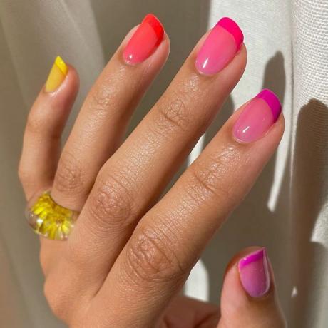 Mujer luce una de las mejores uñas de otoño de 2023, la manicura francesa de colores