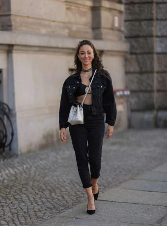 žena na sobě černou džínovou bundu, černé capri kalhoty a černou braletu