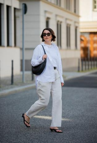 En kvinde bærer et helt hvidt outfit