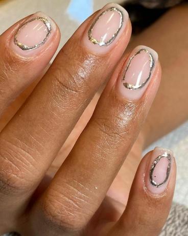 Heldere manicure met zilveren o-vormige ringen