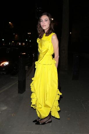Alexa Chung porte une robe jaune avec des chaussures plates en tenue d'invité de mariage