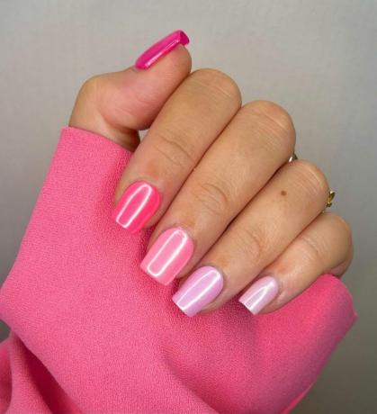 Uma mulher usando um design de unhas simples com tons de rosa