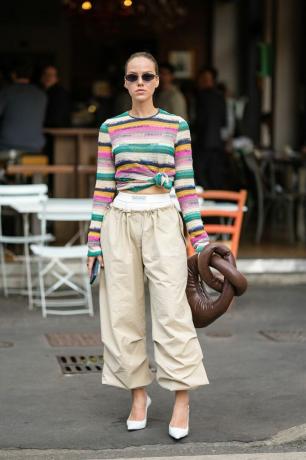 Mujer con camisa a rayas anudada y pantalón caqui. 