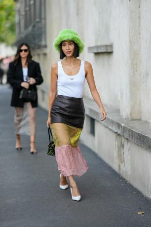 Femme portant un chapeau, une jupe transparente et un débardeur blanc