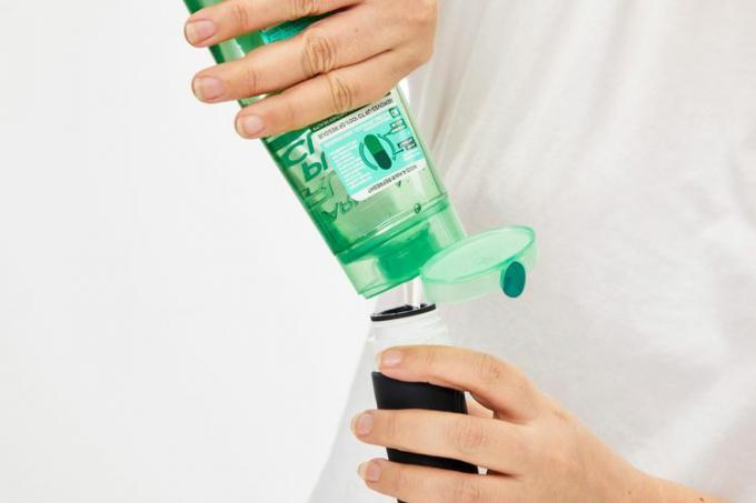 Persoon die de Mrsdry Travel Bottle met product vult