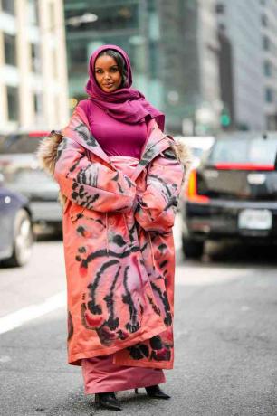 Halima Aden iklädd en lila halsduk och en tie dye lång vinterkappa