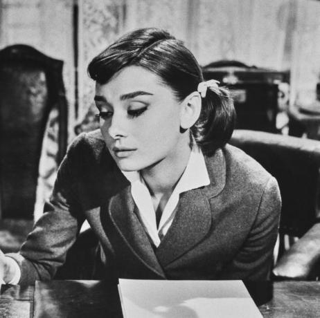 Den britiske skuespilleren Audrey Hepburn (1929-1993) brenner et brev i et fat på et skrivebord i en scene fra 