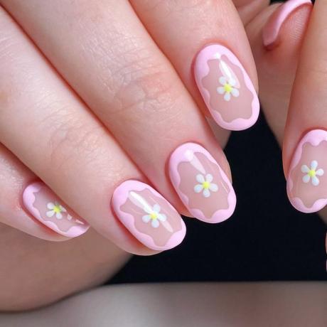 Diseño de uñas naturales con flor rosa enmarcada.