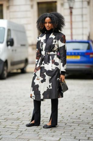 Žena nosí potištěný trenčkot během londýnského týdne módy